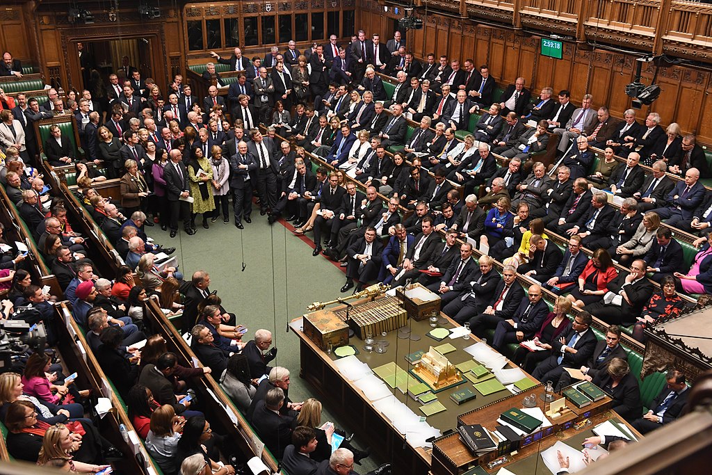 Image of the UK's House of Commons sitting in the chamber during a debate.